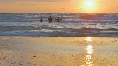 Großmutter-Macht-Mit-Zwei-Enkelkindern-Bodysurfen,-Während-Großvater-Bei-Sonnenuntergang-In-Der-Nordsee-In-Den-Niederlanden-Fotos-Macht