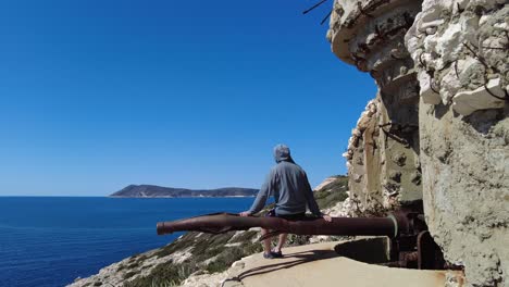 a-visitor-enters-the-Old-Yugoslavian-deserted-military-bunker-on-island-Vis,-Croatia-on-June-18,-2022