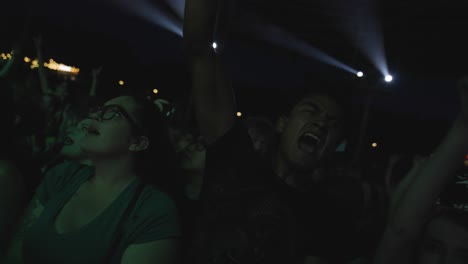 Enérgico-Público-Masculino-Saltando-Y-Cantando-Entre-La-Multitud-Durante-Un-Concierto-De-Rock-En-Vivo-Por-La-Noche.