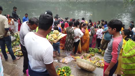 Luftaufnahme-Der-Menschen,-Die-Mit-Früchten-Und-Puja-Artikeln-Auf-Den-Wasserstufen-Des-Ganges-Stehen,-Um-Indische-Hinduistische-Hochzeitsrituale-In-Kalkutta-Durchzuführen