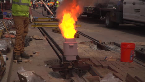 Slow-motion-video-of-Intense-flames-while-a-construction-worker-gets-ready-to-weld-steel-beams-together-for-a-new-railroad-track