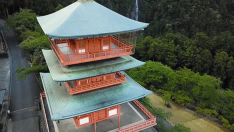 Seiganto-ji-Pagode-Mit-Wasserfällen-In-Der-Ferne,-Beim-Aufstieg-Auf-Das-Dach-Geneigte-Kamera,-24 fps