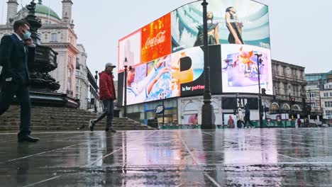 Hombre-De-Negocios-De-Londres-Hablando-Por-Teléfono-Con-Máscara-Covid-Caminando-En-Piccadilly-Circus-Lluvia-Cámara-Lenta