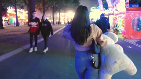 woman-with-tight-pants-and-huge-plushie-elephant-animal-walking-on-a-fun-fair