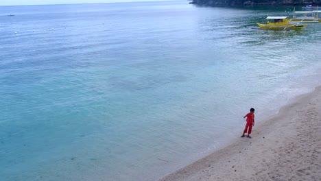 Kleiner-Junge-Steht-Morgens-Am-Strand