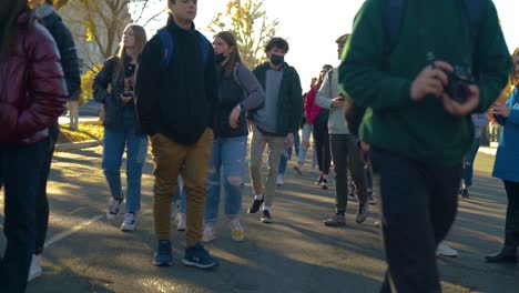 Young-people-walking-past-camera-in-the-middle-of-a-street