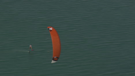 Foil-board-kiter-in-close-up-with-orange-kite