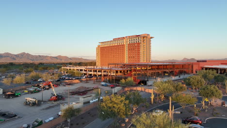 Rising-aerial-view-of-the-Talking-Stick-Resort-building-at-sunset-in-Arizona's-arid-landscape