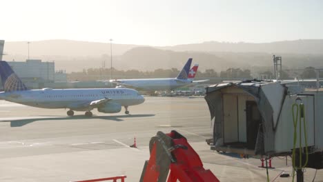 Follow-shot-of-United-airlines-flight-as-it-taxis-to-runway-during-golden-hour