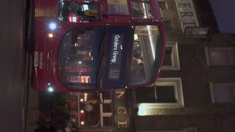 Vertical-Tracking-Shot-Red-Public-Bus-Number-328-Turning-Right-Going-to-Golders-Green-at-Dusk