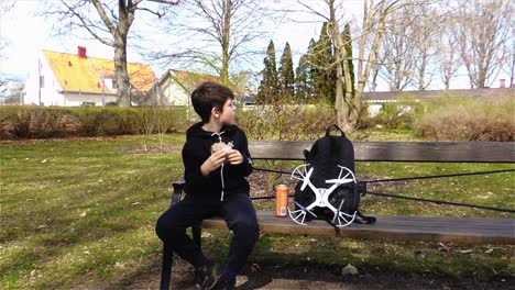 Piloto-De-Drones-Tomando-Un-Descanso-Del-Vuelo-De-Drones,-Almorzando-En-El-Parque-En-Suecia