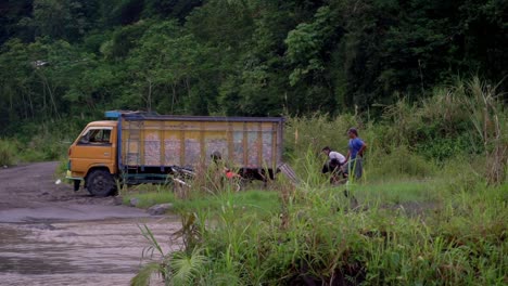 Worker-Men-picking-up-sand-and-loading-on-truck-from-river-during-cloudy-day-in-Indonesia