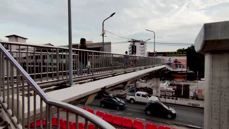 Gente-Asiática-Caminando-Por-El-Paso-Elevado-Sobre-El-Atasco-De-Tráfico-En-Bangkok,-Tailandia