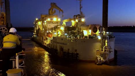 Worker-watches-barge-used-for-dredging-at-night-in-Australian-Port