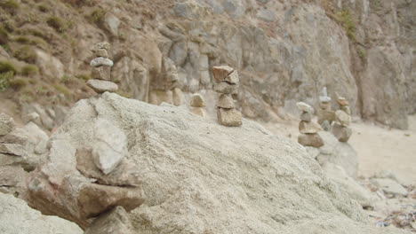 Weite-Aufnahme-Eines-Langsamen-Rack-Fokus-Durch-Eine-Gruppe-Von-Steinhaufen-An-Einem-Strand-Im-Norden-Kaliforniens