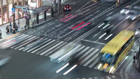 La-Gente-Se-Para-En-La-Acera-Esperando-Cruzar-La-Calle-En-El-Paso-De-Cebra---Tráfico-En-Ginza,-Tokio,-Japón