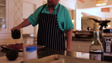 private-chef-pouring-oil-over-beef-while-preparing-dinner