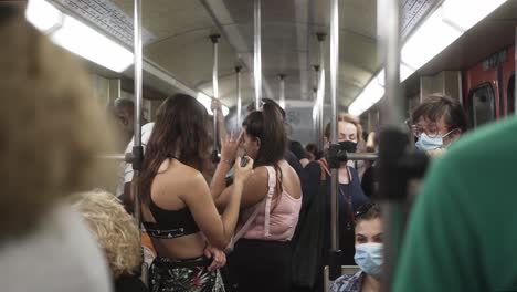 Un-Metro-En-La-Gran-Ciudad-De-Atenas,-Muchas-Personas-Con-Máscaras-Sentadas-Y-Paradas-En-El-Tren