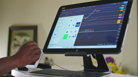 Man-shutting-down-his-2-in-1-home-windows-10-computer-with-day-trading-stock-charts-still-running-on-the-screen