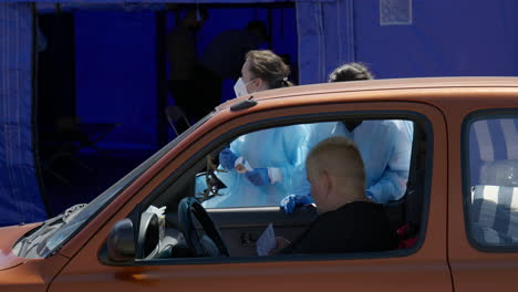 Close-up-of-two-medical-assistants-giving-papers-to-a-woman-who-is-going-to-get-the-Pfizer-BioNTech-vaccine-in-the-second-drive-through-COVID-19-vaccination-center-in-Romania