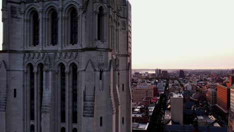 Aerial-view-around-the-Riverside-Church,-revealing-the-Claremont-hall,-sunset-in-Uptown-Manhattan---orbit,-drone-shot