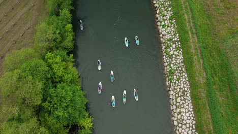 Drone-following-paddleboards-above-the-river-in-Slovenia,-Vipava