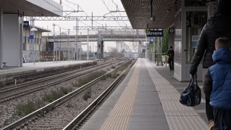 Gente-Caminando-Cerca-De-Los-Rieles-Del-Tren-En-La-Estación