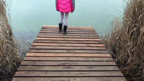 clip-of-a-girl-standing-on-a-dock-as-the-camera-slowly-pans-up-to-revel-a-city