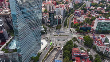 órbita-Aérea-De-La-Rotonda-De-La-Torre-Manacar-Tráfico-Diurno-En-La-Ciudad-De-México,-Timelapse-Desde-Arriba-De-La-Torre