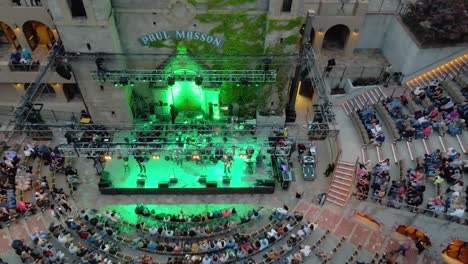 Aerial-view-of-a-band-performing-at-the-mountain-winery-in-California---tilt,-drone-shot