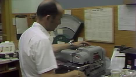 1970S-POSTAL-WORKER-HELPS-A-CUSTOMER-MAIL-A-LETTER-AT-POST-OFFICE