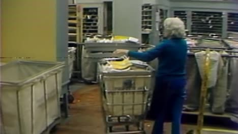 1970S-INSIDE-POST-OFFICE-EMPLOYEE-MOVING-MAIL