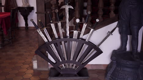 Ornate-sword-display-in-medieval-themed-room-with-wooden-furnishings