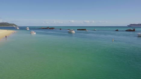 Boats-and-tourists-enjoy-the-clear-blue-waters-and-sandy-shores-of-Moreton-Island,-Australia