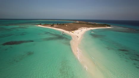 A-tropical-island-with-turquoise-waters-and-a-sandy-isthmus-connecting-to-another-island,-aerial-view