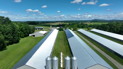 Rising-drone-wide-shot-of-long-stables-and-barn-on-scenic-farm-in-America