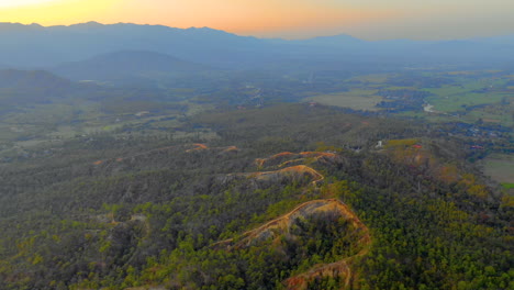 Atemberaubende-Luftaufnahme-Des-Sonnenuntergangs-über-Den-Bergen-In-Der-Thailändischen-Landschaft