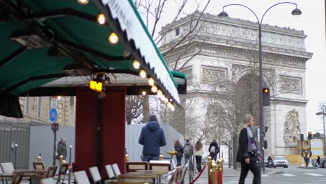 Camera-pans-from-an-empty-restaurant-to-the-Arc-De-Triomphe-while-an-attractive-woman-walks-past