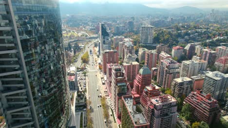 Drone-passing-the-Titanium-tower,-over-the-Vitacura-street-in-Santiago-de-Chile