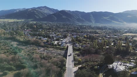 Trucks-cross-a-bridge-over-a-majestic-hilly-landscape-in-Tafí-del-Valle,-Tucumán,-Argentina