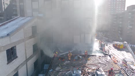 Valientes-Bomberos-En-La-Cima-De-Un-Edificio-De-Apartamentos-En-Un-Entorno-Urbano-Extinguiendo-Y-Activando-El-Incendio