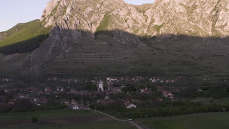 Romanian-Village-in-the-valley-in-front-of-Piatra-Secuiului-Mountain-at-sunset