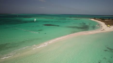 Kitesurfers-enjoying-the-crystal-clear-waters-of-Cayo-de-Agua-on-a-sunny-day,-aerial-view