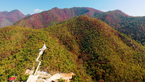 Vista-Aérea-De-Un-Templo-Y-Una-Estatua-De-Buda-En-Las-Colinas-De-Pai,-Tailandia