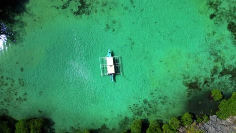 Kayangan-Lake-Timelapse-Of-Drone-Aerial-Ascending-With-Camera-Pointed-Downwards-At-Tour-Boat-In-Northern-Palawan