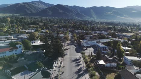 Forward-shot-of-housing-and-streets-in-the-town-of-Tafí-del-Valle-in-Tucumán,-Argentina-with-a-line-of-hills-in-the-background