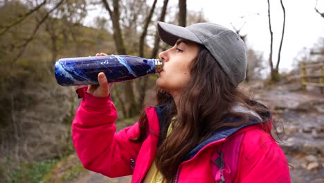 Complete-process-of-a-woman-opening,-drinking-from,-and-closing-a-water-bottle-in-Brecon-Beacons-National-Park,-Wales