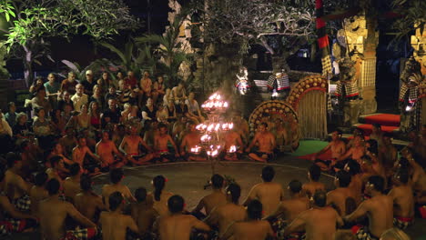 Kecak-Fire-Dance-Performance-in-Ubud,-Bali,-local-performers-sitting-around-burning-candles-and-screaming-"Kecak"-trance-in-the-beginning-of-the-show-at-night-Temple