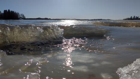 Ice-melting-in-spring-at-frozen-sea,-water-flooding-in-spring