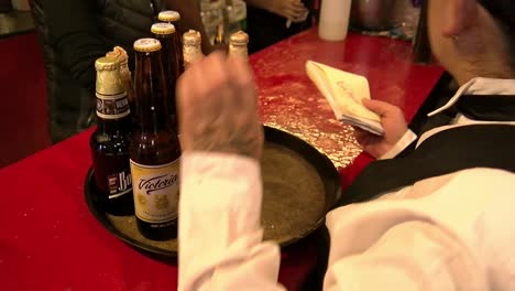 Waitress-serving-traditional-Mexican-beers-while-calculating-the-bill